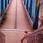 On a pedestrian bridge and in a park