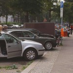 On a park bench next to the street