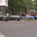 On a park bench next to the street