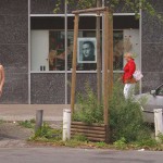 On a park bench next to the street