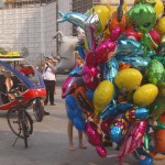 At an open square giving away balloons